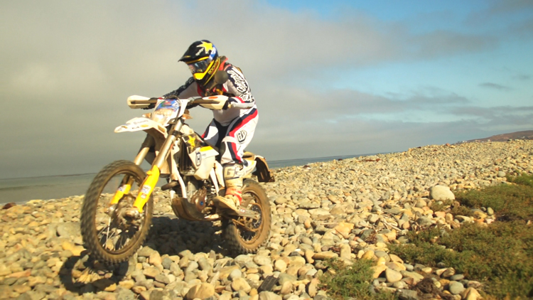 Manny "King Squirrel" Orneals pulling a wheely on the beach rocks.